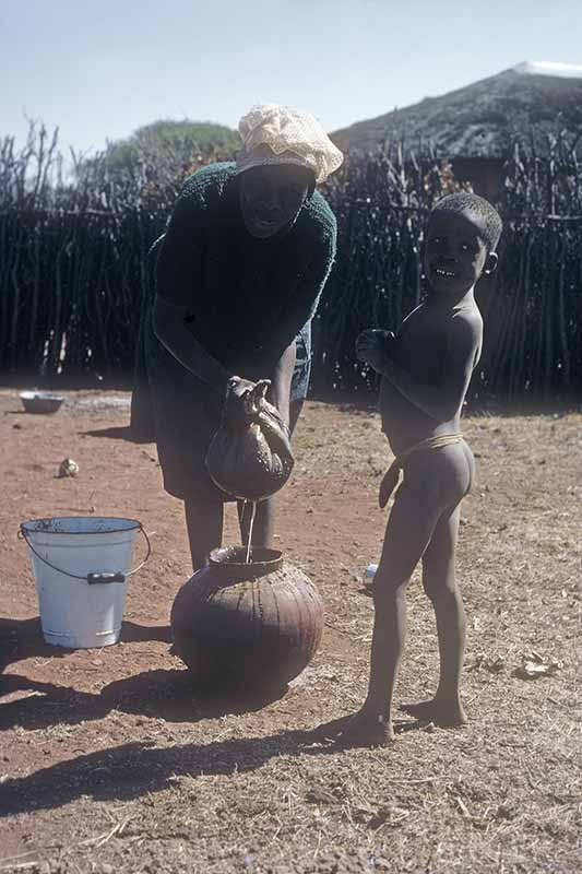 Woman preparing maize beer, Kanye