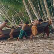 Dragging a canoe onto the beach