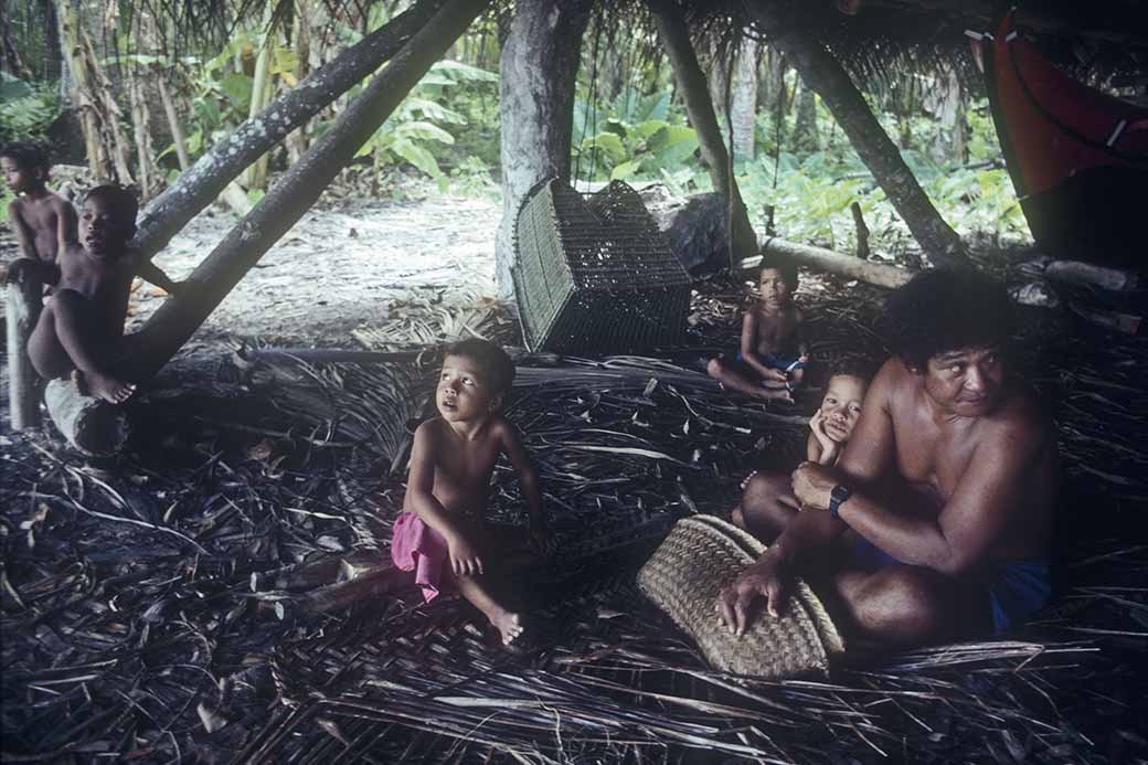 Man and boys in canoe house