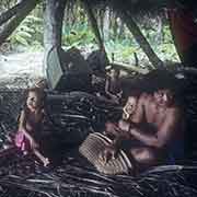 Man and boys in canoe house